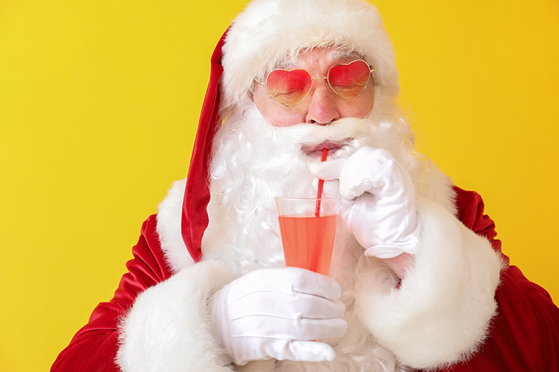 Santa Claus drinking cocktail on color background